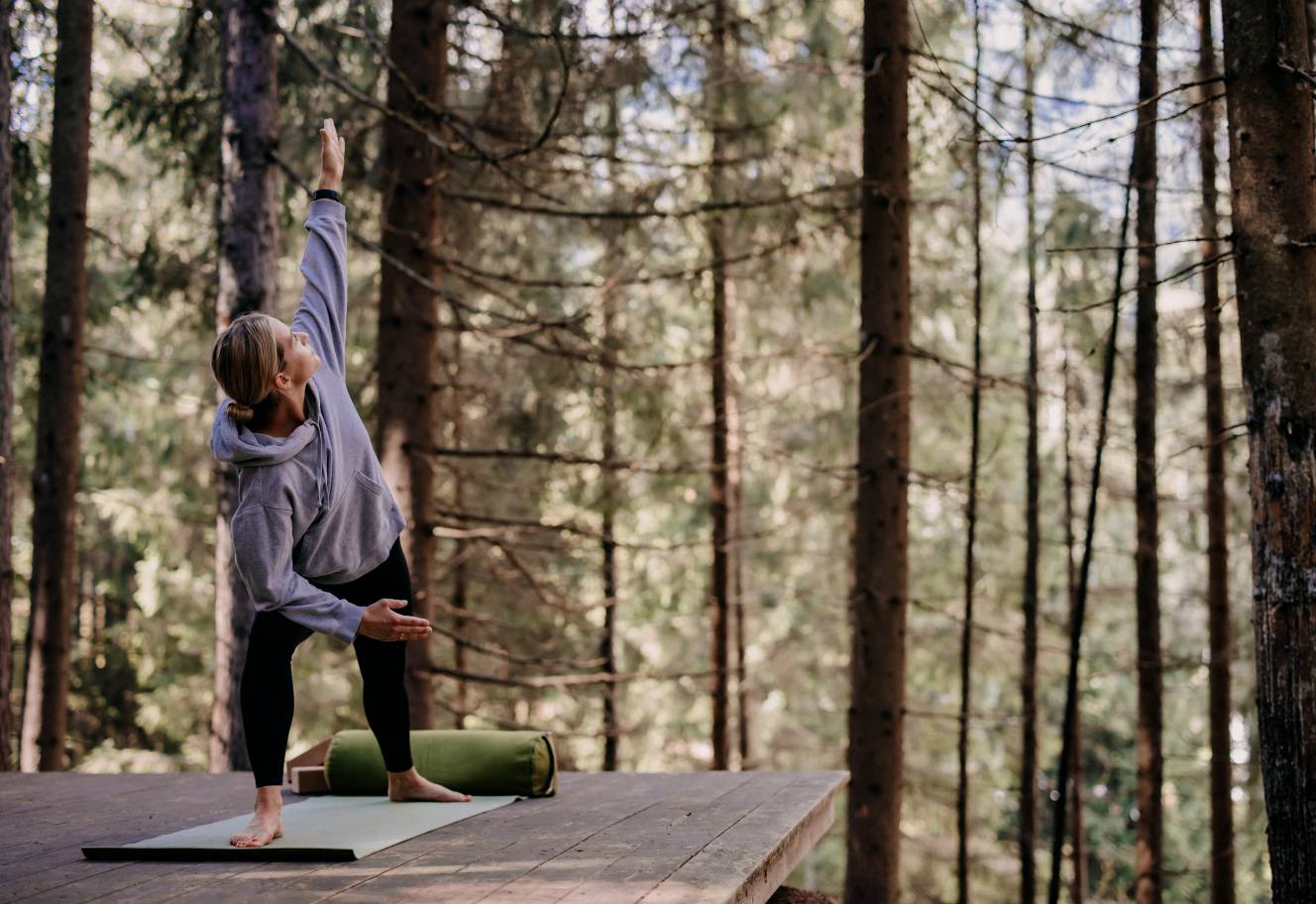 Yoga retreat at the Forsthofgut - Woman doing yoga in the woods